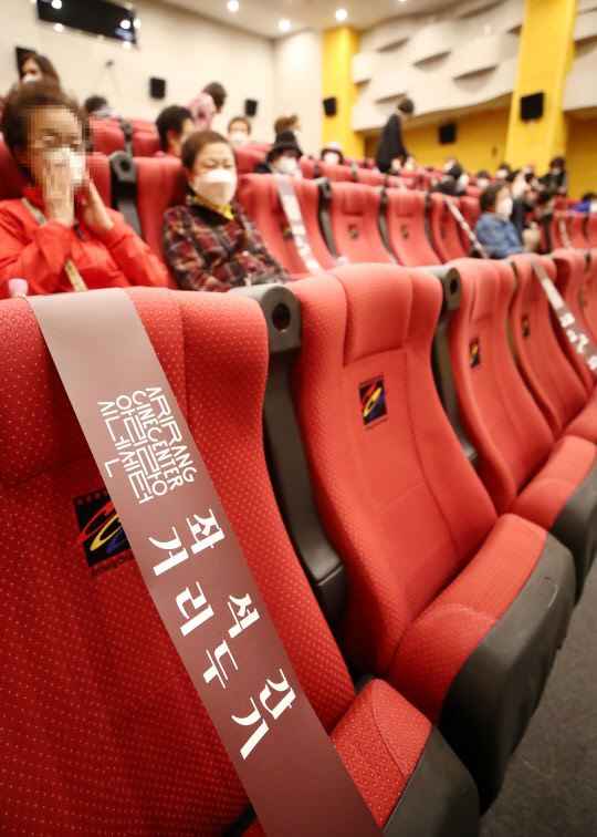 지난 11일 오전 서울 성북구 아리랑시네센터에서 열린 '어울림 문화 나들이 - 영화 미나리 단체관람'에 참석한 어르신들이 거리를 두고 앉아 있다. <연합뉴스>